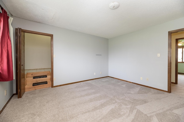 unfurnished bedroom with baseboards, carpet floors, and a textured ceiling