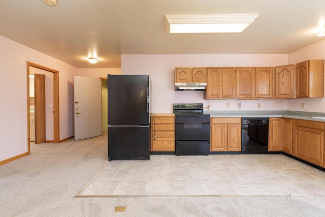 kitchen featuring under cabinet range hood, light countertops, washer / dryer, black appliances, and a sink