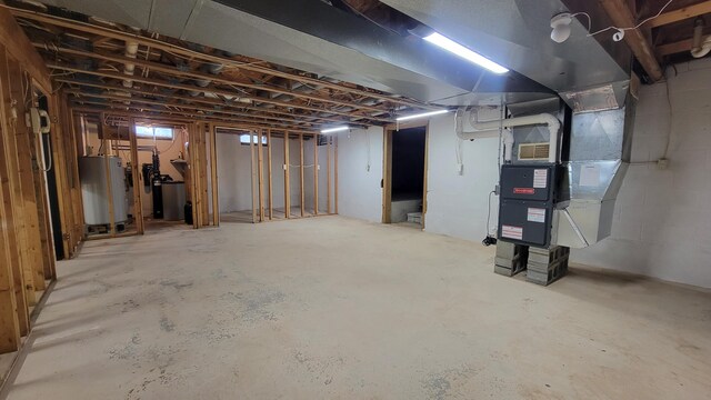 unfinished basement with water heater and heating unit