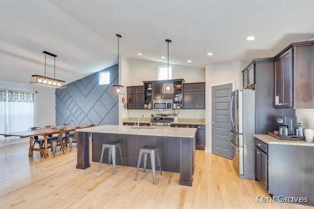 kitchen with a sink, appliances with stainless steel finishes, light wood-type flooring, and a healthy amount of sunlight