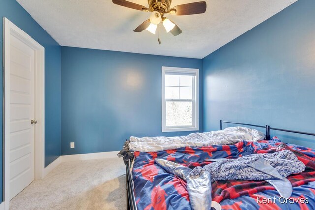 carpeted bedroom featuring baseboards and a ceiling fan