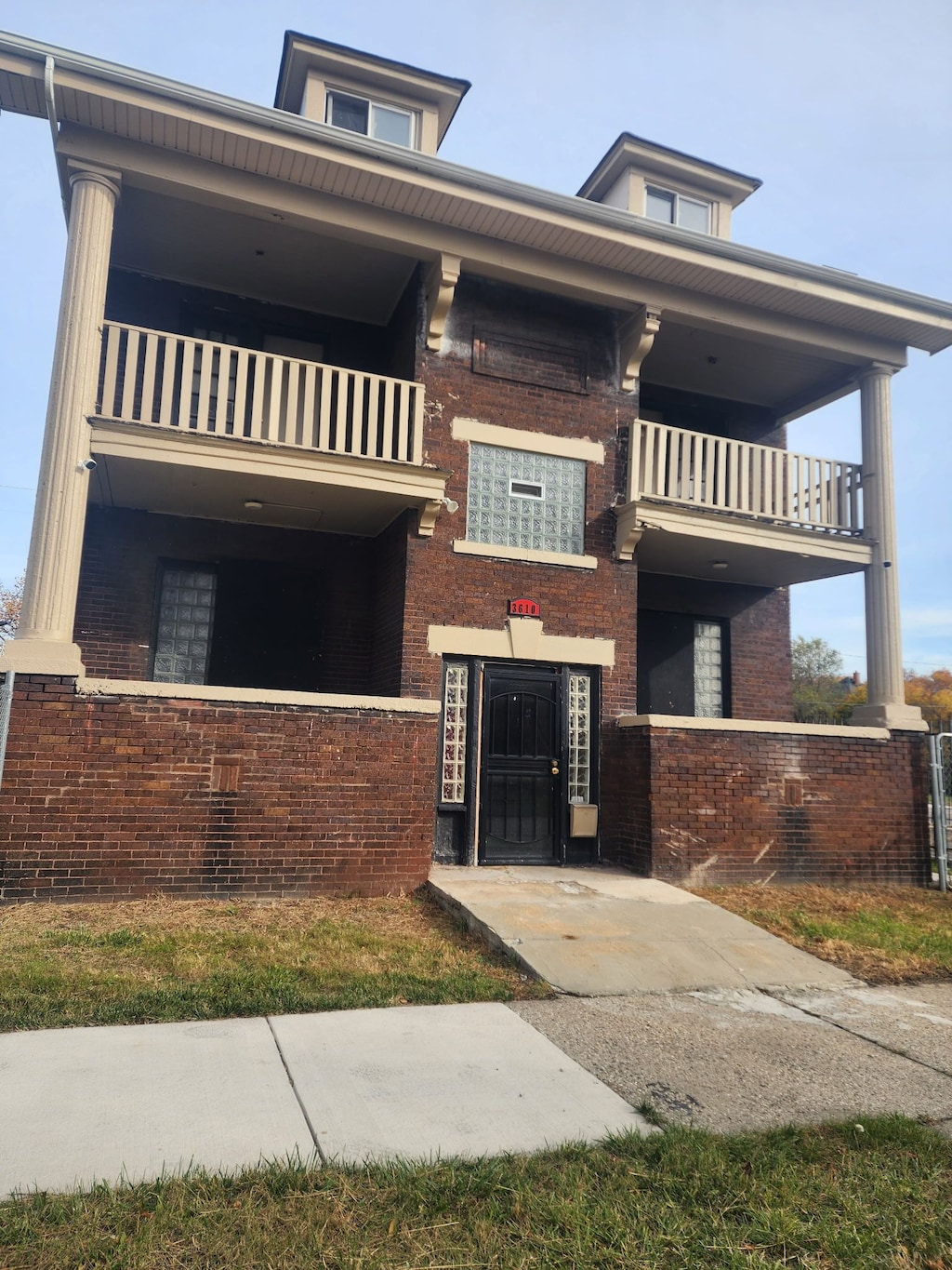 view of front of property featuring brick siding and a balcony