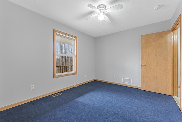spare room with carpet, visible vents, ceiling fan, and baseboards