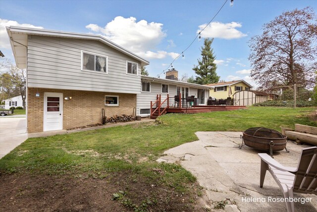 1456 54th St SE, Grand Rapids, MI 49508 - rear view of property featuring a fire pit, a wooden deck, a chimney, brick siding, and a lawn