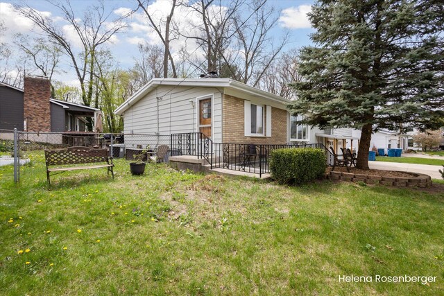 1456 54th St SE, Grand Rapids, MI 49508 - view of property exterior with brick siding, fence, and a yard
