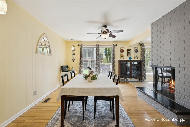 1456 54th St SE, Grand Rapids, MI 49508 - dining room featuring visible vents, a fireplace, baseboards, a ceiling fan, and light wood finished floors