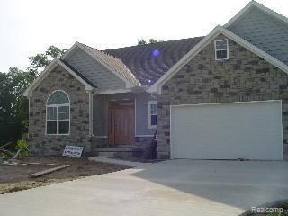14922 Wildwood Dr, Monroe, MI 48161 - craftsman-style house featuring driveway, stone siding, and an attached garage