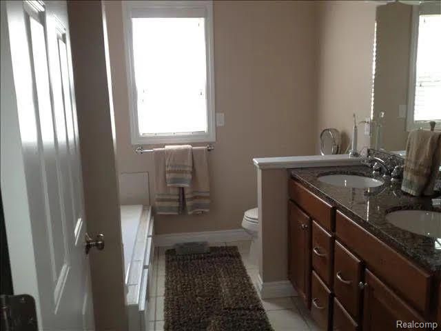 14922 Wildwood Dr, Monroe, MI 48161 - full bathroom featuring toilet, tile patterned flooring, a sink, and double vanity