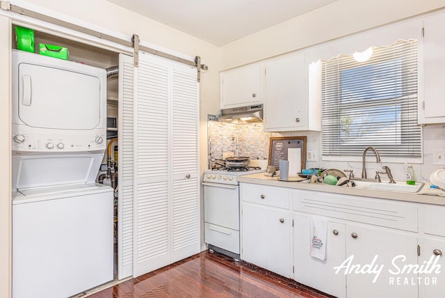 3817 Boone Ave SW, Wyoming, MI 49519 - kitchen featuring a sink, under cabinet range hood, white range with gas cooktop, tasteful backsplash, and stacked washer / dryer