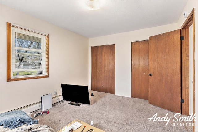 3817 Boone Ave SW, Wyoming, MI 49519 - unfurnished bedroom with a baseboard heating unit, carpet, and multiple closets