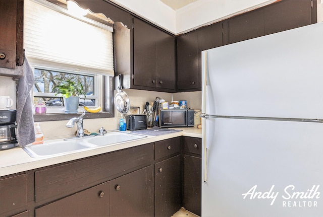 3817 Boone Ave SW, Wyoming, MI 49519 - kitchen featuring a sink, black microwave, light countertops, freestanding refrigerator, and dark brown cabinetry