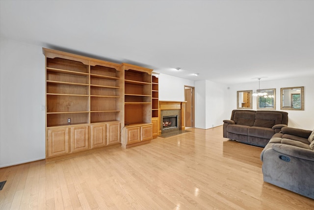 29691 Sierra Pointe Cir, Farmington Hills, MI 48331 - living area featuring an inviting chandelier, a lit fireplace, and light wood-style flooring