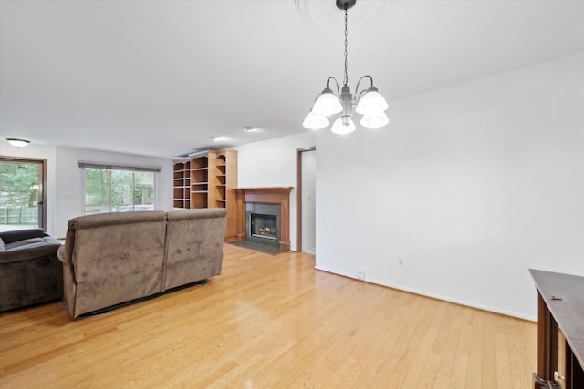 29691 Sierra Pointe Cir, Farmington Hills, MI 48331 - living room featuring a fireplace with flush hearth, an inviting chandelier, and light wood finished floors