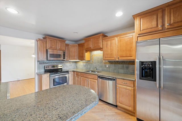 29691 Sierra Pointe Cir, Farmington Hills, MI 48331 - kitchen with light stone counters, a sink, light wood finished floors, stainless steel appliances, and tasteful backsplash