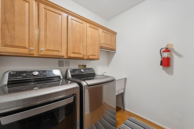 29691 Sierra Pointe Cir, Farmington Hills, MI 48331 - clothes washing area with baseboards, light wood finished floors, cabinet space, and washer and dryer
