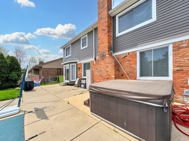 exterior space featuring fence and a hot tub