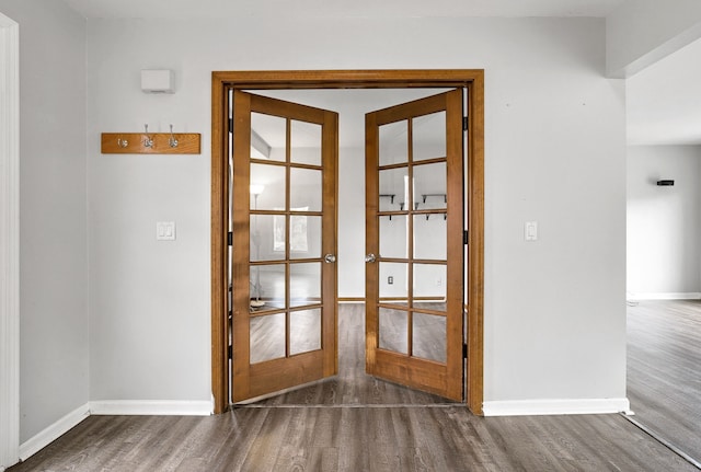 doorway with wood finished floors, french doors, and baseboards