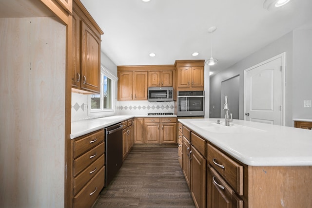 kitchen featuring a sink, decorative backsplash, stainless steel appliances, dark wood-type flooring, and light countertops