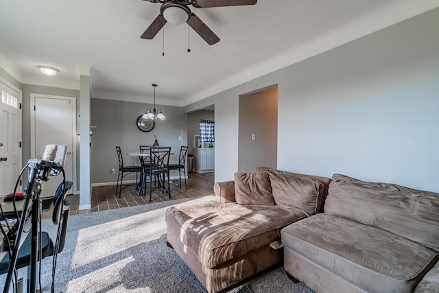 living room with baseboards, ceiling fan, and carpet flooring