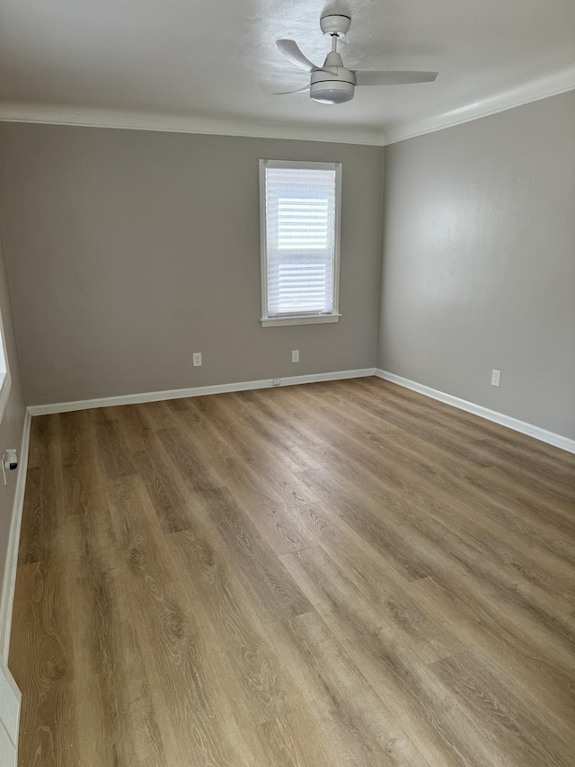 empty room featuring wood finished floors, ceiling fan, and crown molding