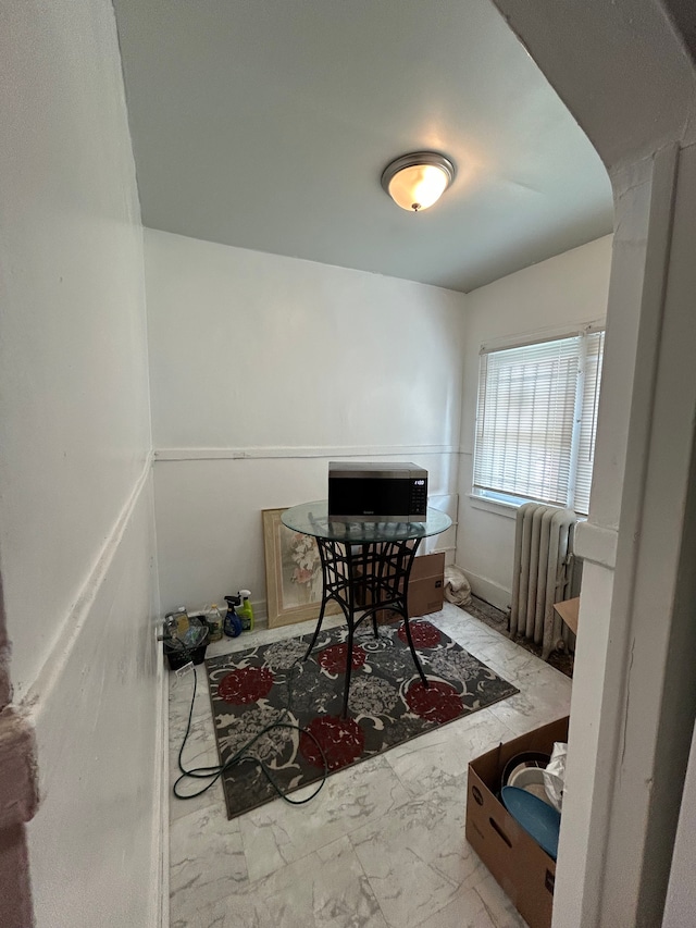 interior space featuring radiator heating unit, marble finish floor, and arched walkways