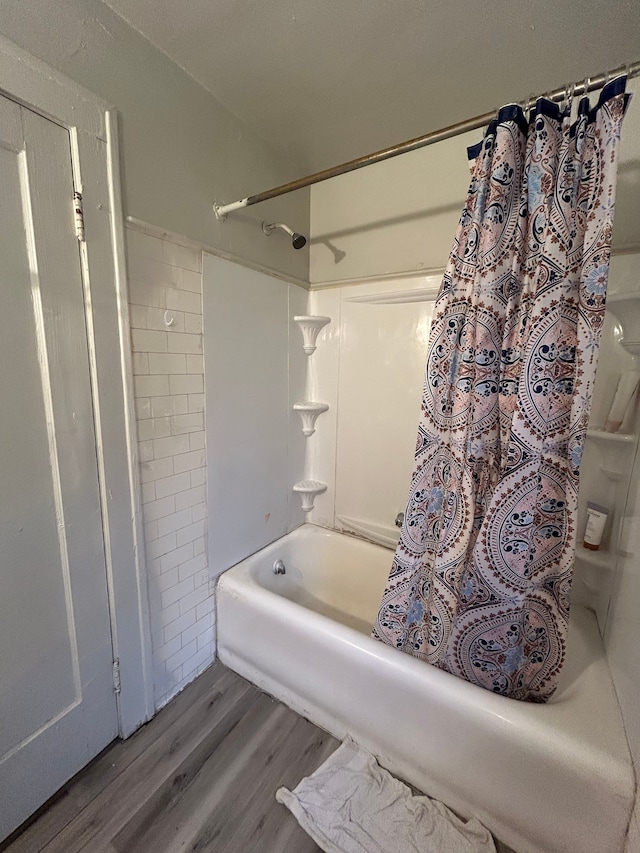 bathroom featuring wood finished floors and shower / bath combination with curtain