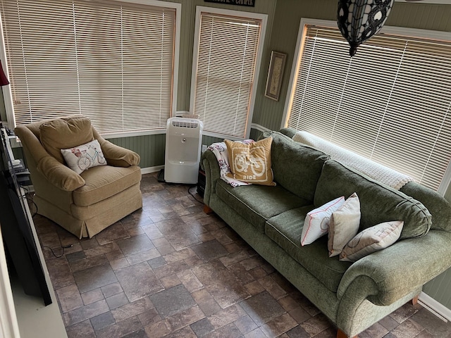 living area featuring stone tile flooring and baseboards