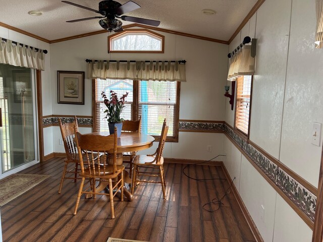 dining space featuring wood finished floors, ceiling fan, ornamental molding, and lofted ceiling