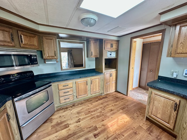 1088 Kern Rd, Fowlerville, MI 48836 - kitchen with appliances with stainless steel finishes, dark countertops, light wood-style flooring, crown molding, and brown cabinetry