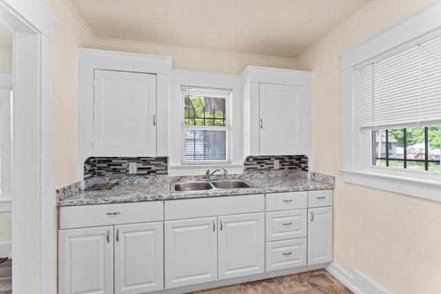 203 E Stewart Ave, Flint, MI 48505 - kitchen with a sink, decorative backsplash, healthy amount of natural light, white cabinets, and ornamental molding