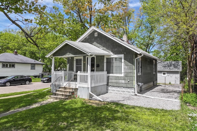 203 E Stewart Ave, Flint, MI 48505 - bungalow-style home featuring covered porch, a chimney, and a front yard
