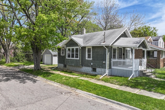 203 E Stewart Ave, Flint, MI 48505 - view of front of house featuring covered porch, a detached garage, a chimney, an outdoor structure, and a shingled roof