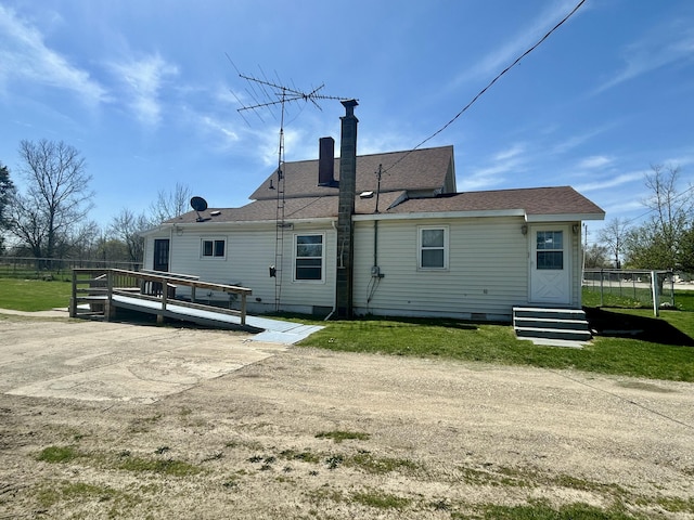 rear view of house featuring a deck, a chimney, entry steps, crawl space, and a lawn