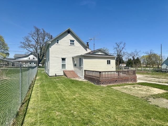 back of property featuring a deck, fence, and a yard