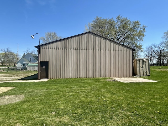view of pole building featuring a lawn and fence