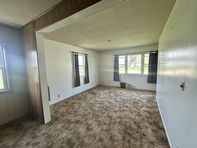 carpeted empty room with a textured ceiling