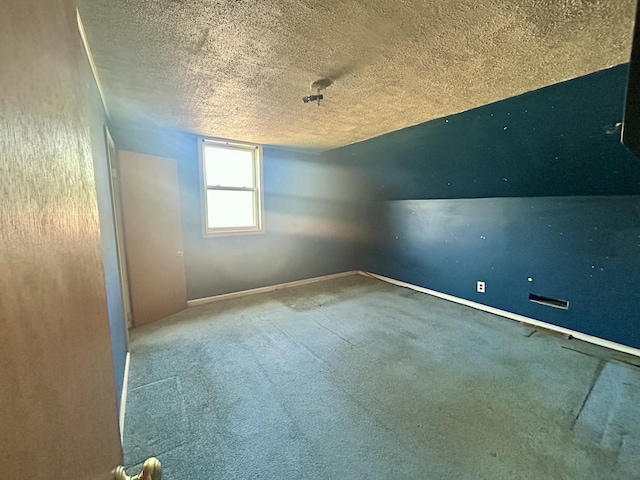 empty room with baseboards, a textured ceiling, and carpet flooring