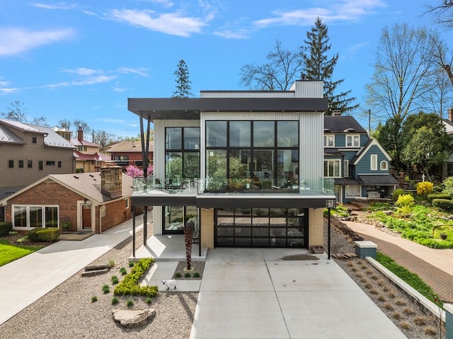 contemporary house with a garage, concrete driveway, and a residential view