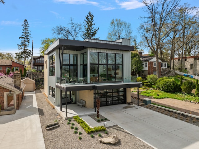 back of property featuring a sunroom and an outdoor structure
