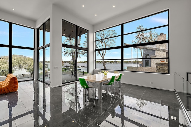 sunroom with plenty of natural light and a water view