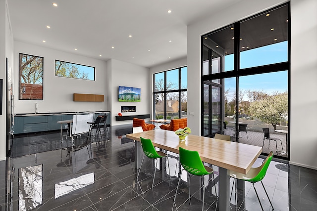 dining room with recessed lighting, healthy amount of natural light, and a high ceiling