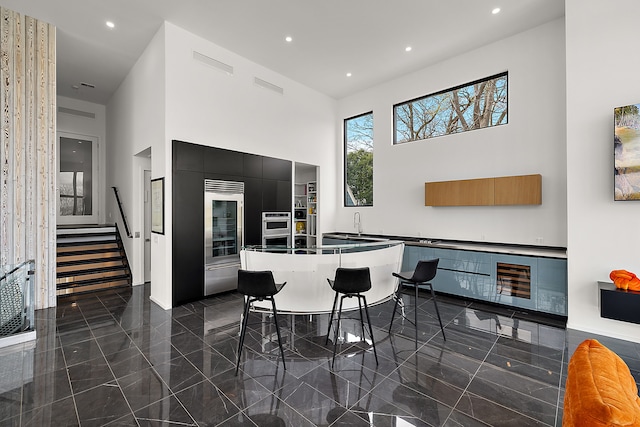 dining room with a high ceiling, granite tiled floors, recessed lighting, and stairs