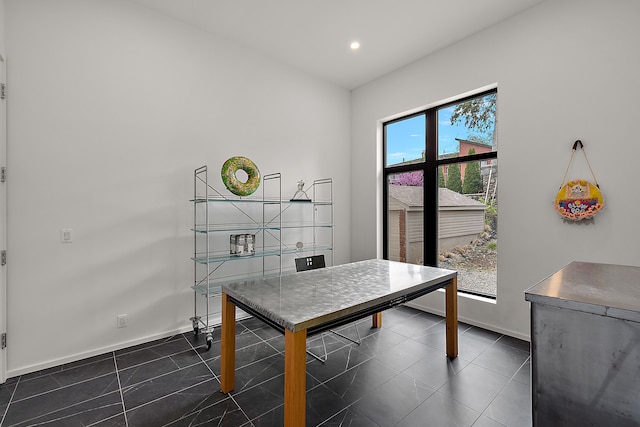 dining room featuring dark tile patterned floors, baseboards, and recessed lighting