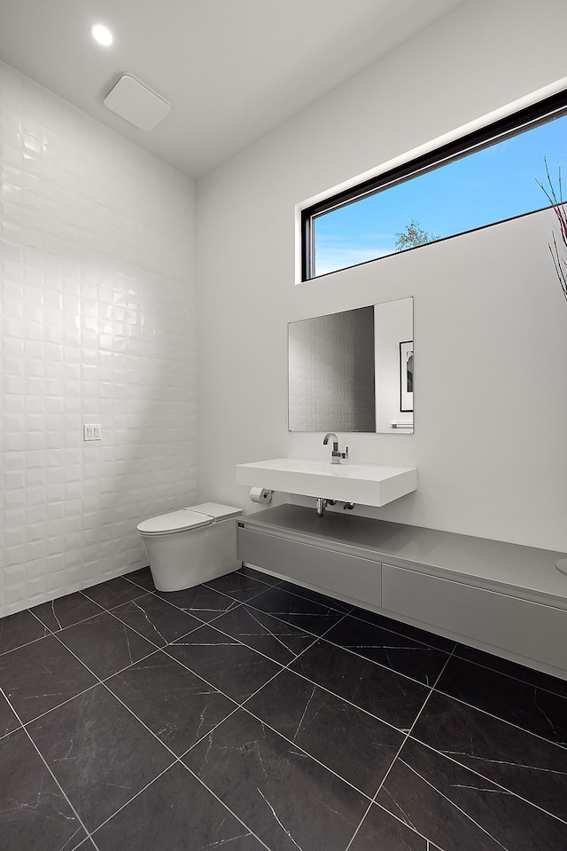 half bath featuring toilet and a sink