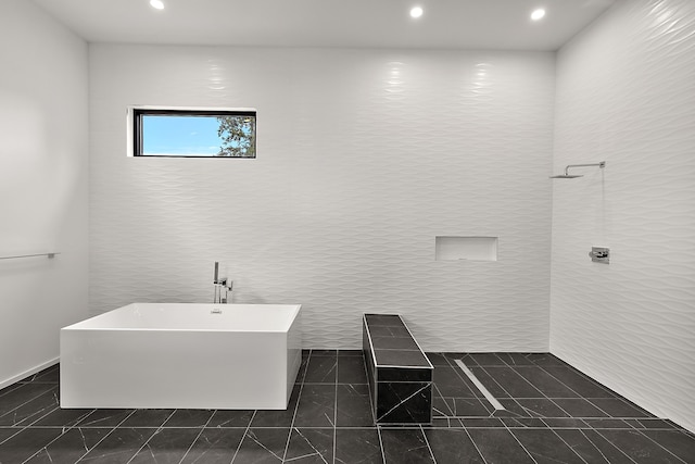 bathroom with a freestanding bath, recessed lighting, and tile patterned flooring