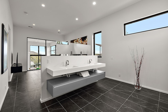 bathroom featuring recessed lighting, baseboards, marble look tile flooring, and double vanity