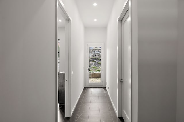 hall featuring dark tile patterned flooring, recessed lighting, and baseboards