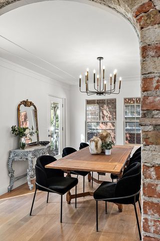 2423 Chicago Blvd, Detroit, MI 48206 - dining space featuring a chandelier, ornamental molding, arched walkways, and light wood finished floors