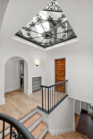 2423 Chicago Blvd, Detroit, MI 48206 - staircase featuring wood finished floors, baseboards, and arched walkways