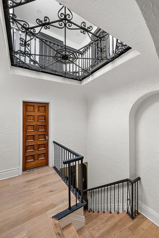 2423 Chicago Blvd, Detroit, MI 48206 - stairway featuring baseboards, wood finished floors, a high ceiling, and a textured wall